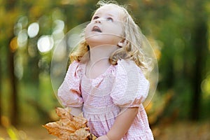 happy little child, baby girl laughing and playing in the autumn on the nature walk outdoors