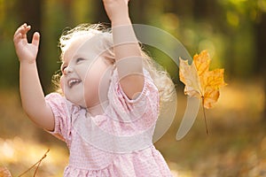 happy little child, baby girl laughing and playing in the autumn on the nature walk outdoors