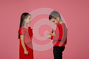 Happy little child boy gives smiling girl a gift box