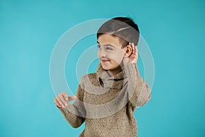 Happy little child boy making hearing gesture