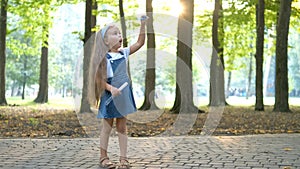 Happy little child girl blowing soap bubbles outside in green park. Outdoor summer activities for children concept