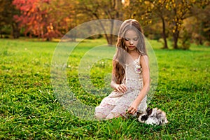 Happy little child girl with cute rabbit. Portrait of kid with pet