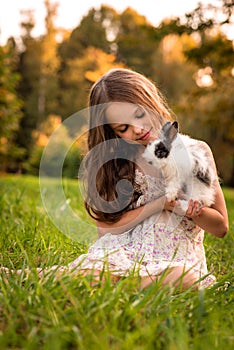 Happy little child girl with cute rabbit. Portrait of kid with pet