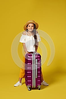 Happy little child girl in hat with pink suitcase