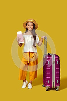 Happy little child girl in hat with pink suitcase