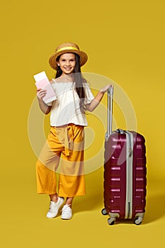 Happy little child girl in hat with pink suitcase