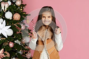 Little child girl holding lollipop candy cane