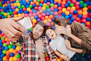 Happy little child have fun with his parents make selfie