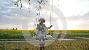 Happy little child have fun sway spin on swing on nature sunset, Female kid swaying, in forest park, children on swing,