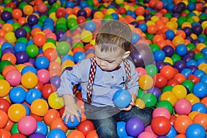 Happy little child playing at colorful plastic balls playground