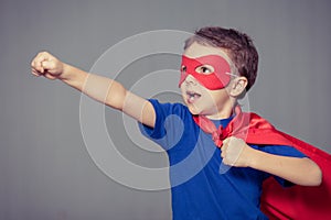 Happy little child playing superhero.