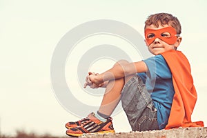 Happy little child playing superhero.