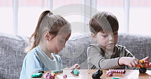 Happy little children developing fine hands motility, using playdough.