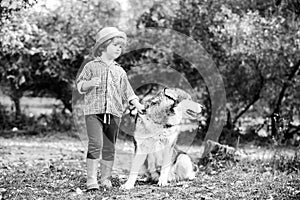 Happy little children having fun with dog pet on field. Children are hiking together with pet dog. Kid boy having