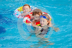 Happy little children playing in the swimming pool