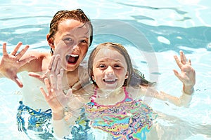 Happy little children swimming in pool together