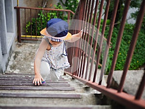 Happy little cute girl climbing the stair to the upstair. Happy