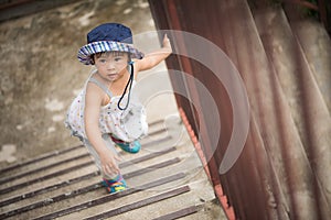Happy little cute girl walking up the stairs.