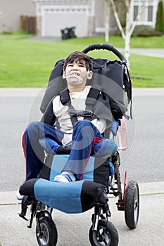 Happy little disabled boy in wheelchair