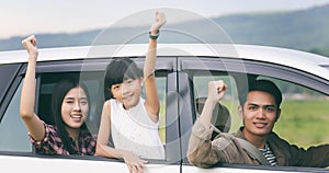 Happy little girl with asian family sitting in the car for enjo