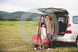 Happy little girl with asian family sitting in the car for enjoying road trip and summer vacation in camper van