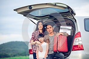 Happy little girl  with asian family sitting in the car for enjoying road trip and summer vacation in camper van