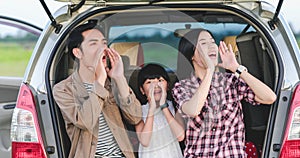 Happy little girl  with asian family sitting in the car for enjoying road trip and summer vacation in camper van