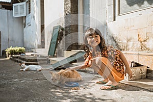 Asian playing with cat at java traditional home