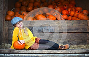 Happy little girl at the autumn pumpkin patch background
