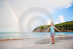 Happy little girl backgound the beautiful rainbow over the sea. Beautiful rainbow on caribbean beach