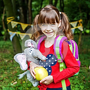 Happy little girl with a backpack. Square. The concept is back t