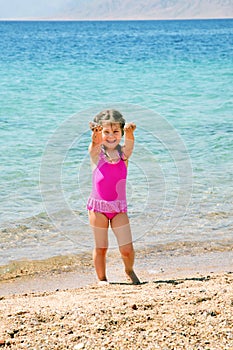 Happy little girl on the beach playing