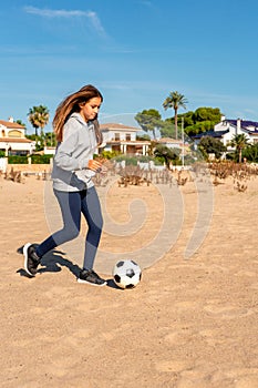 Happy little girl on the beach plays with a ball on the sand. Travel and leisure