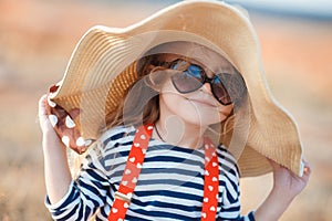 The happy little girl in a big hat