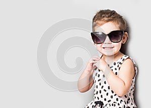 Happy little girl with big sunglasses. Fashionable baby