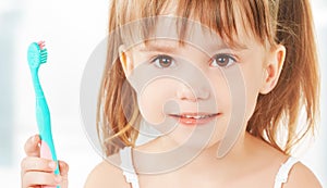 Happy little girl brushing her teeth