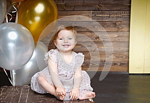 Happy little girl celebrate her first birthday party with balloons