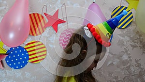 happy little girl celebrates birthday, balloons and decorations. the candles on the cake blow out. Happy group of