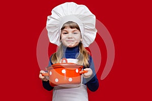 Happy little girl in chef uniform holds saucepan