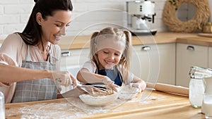 Happy mom and daughter prepare pie in kitchen