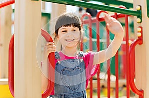 Happy little girl climbing on children playground