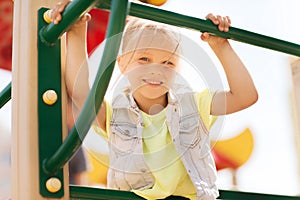 Happy little girl climbing on children playground