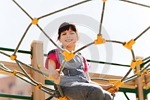 Happy little girl climbing on children playground