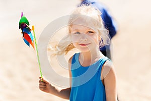 Happy little girl with colorful pinwheel at summer