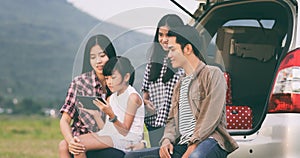 Happy little girl e with asian family sitting in the car for enjoying road trip and summer vacation in camper van