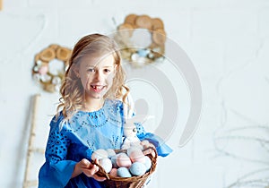 Happy little girl in Easter with a basket of eggs