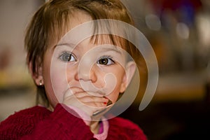 Happy little girl eating chocolate