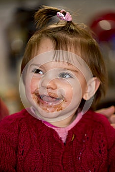 Happy little girl eating chocolate