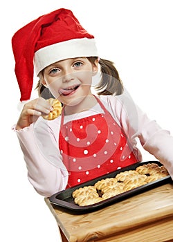 Happy little girl eating Christmas cookies