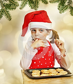 Happy little girl eating Christmas cookies